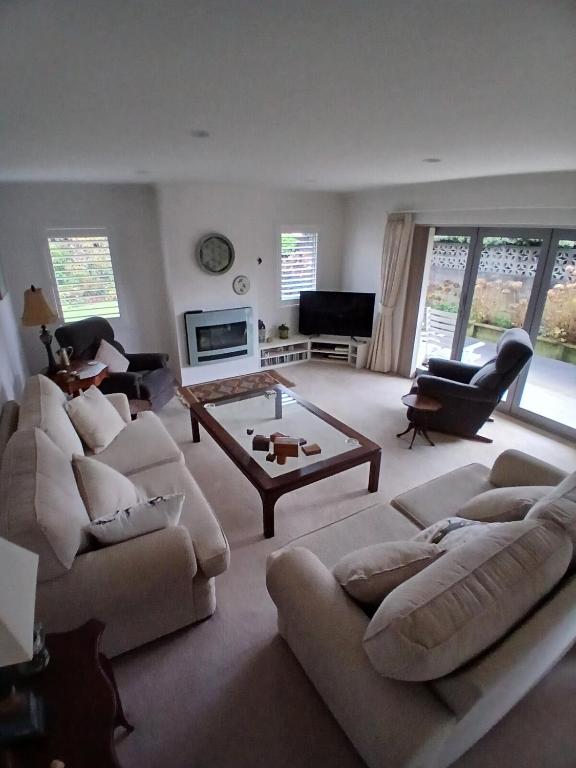 a living room with two couches and a coffee table at Modern Home in Central Location in New Plymouth