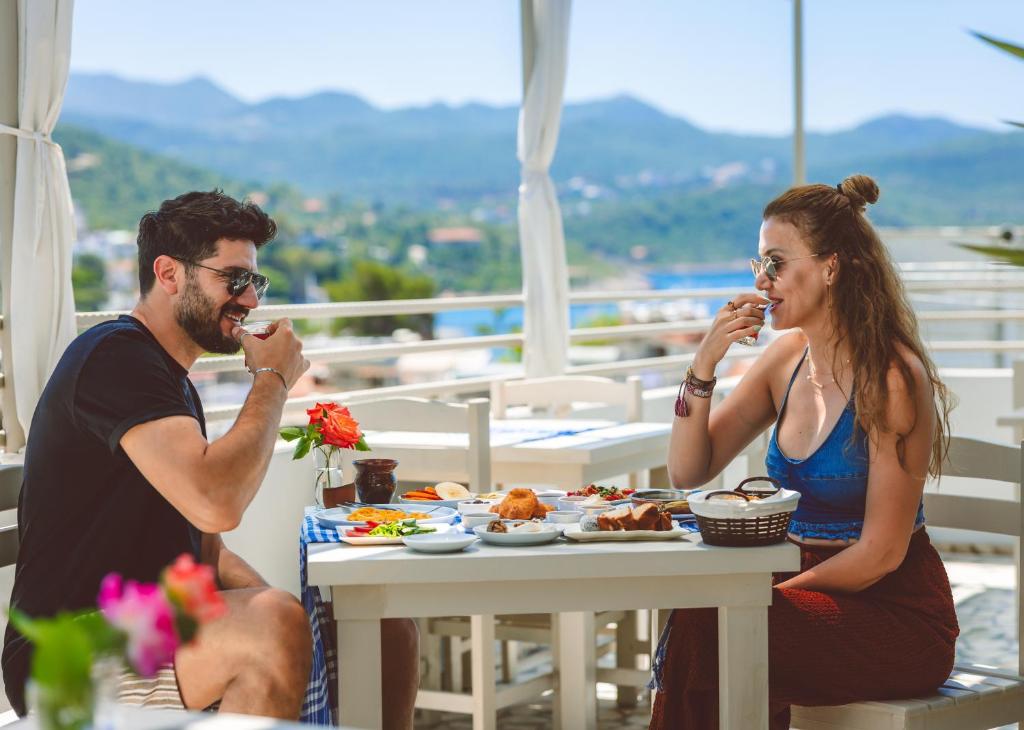 a man and a woman sitting at a table eating food at Kaşhan Otel in Kaş