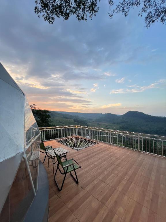 a deck with two chairs and a table on a balcony at Nualam Glamping in Pasirangin