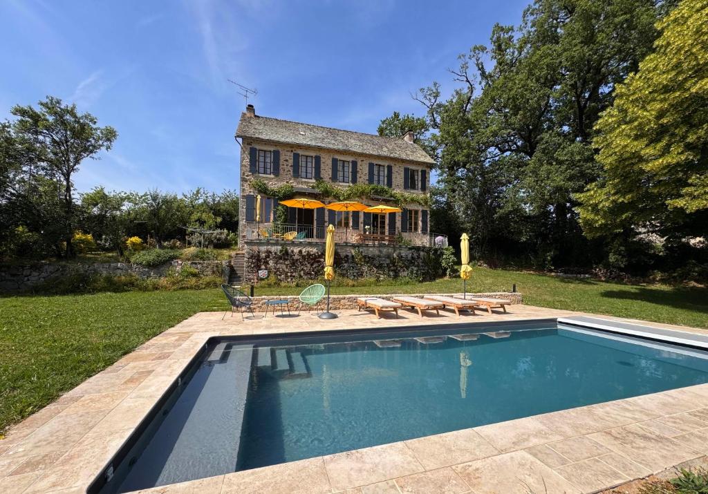 a house with a swimming pool in front of a house at Le Couvent in Lunac