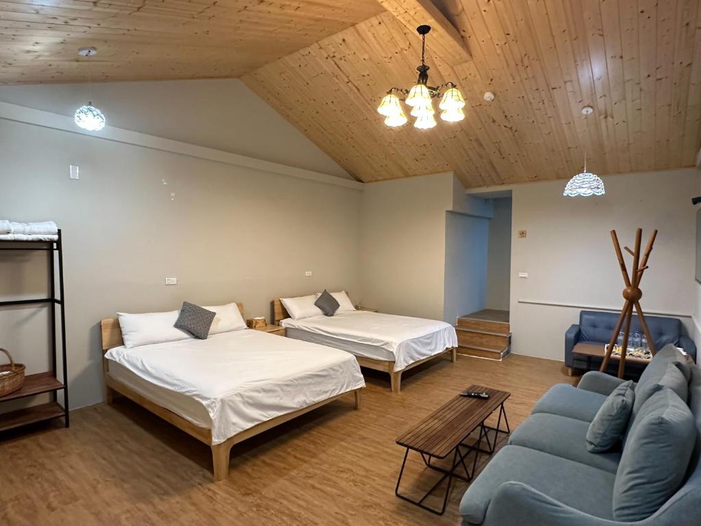 a living room with two beds and a couch at 旅人路過時民宿 in Hsi-lo