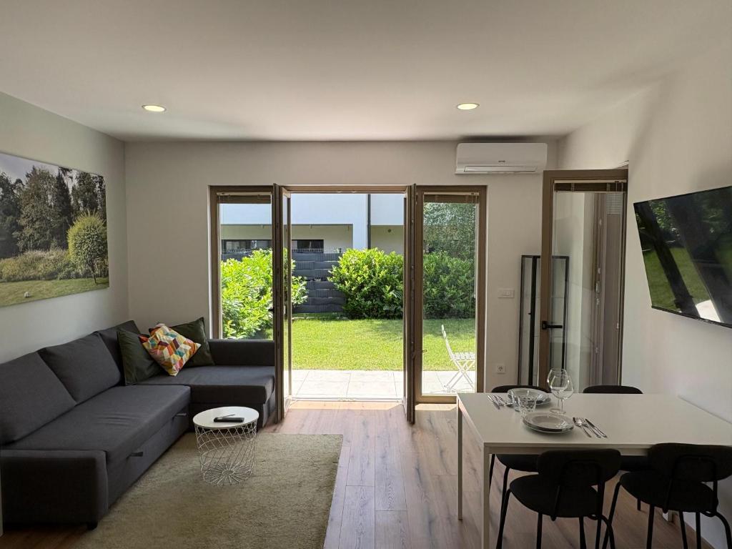 a living room with a couch and a table at Zbilje Lakeside Apartment in Medvode