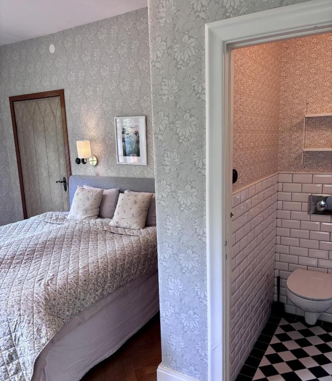 a bedroom with a bed and a walk in shower at Minnesberg Bed & Breakfast in Trelleborg