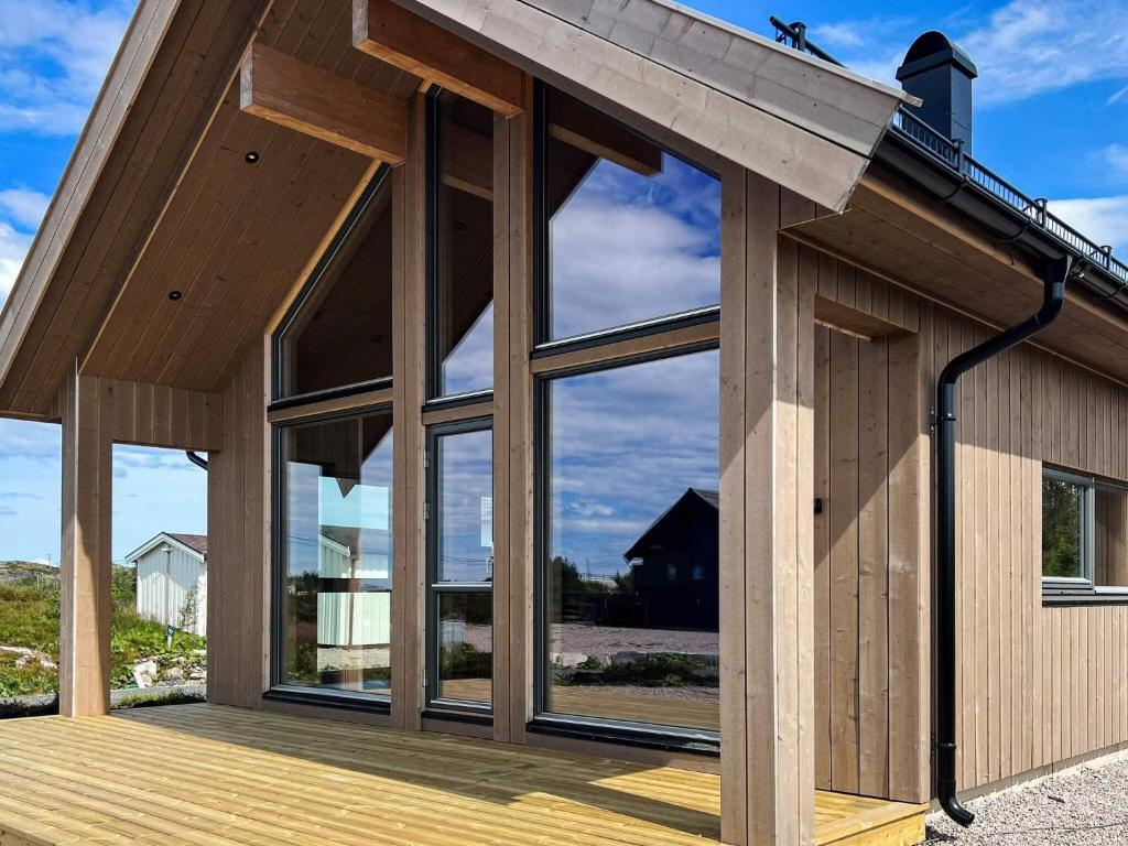 a wooden house with large windows on a deck at 6 person holiday home in Averøya in Karvåg