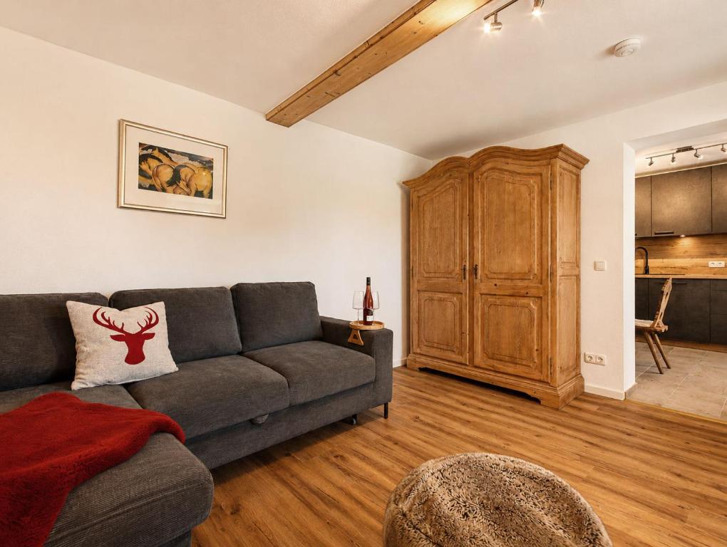 a living room with a couch and a wooden cabinet at Guade Stub'n Franzi in Huglfing