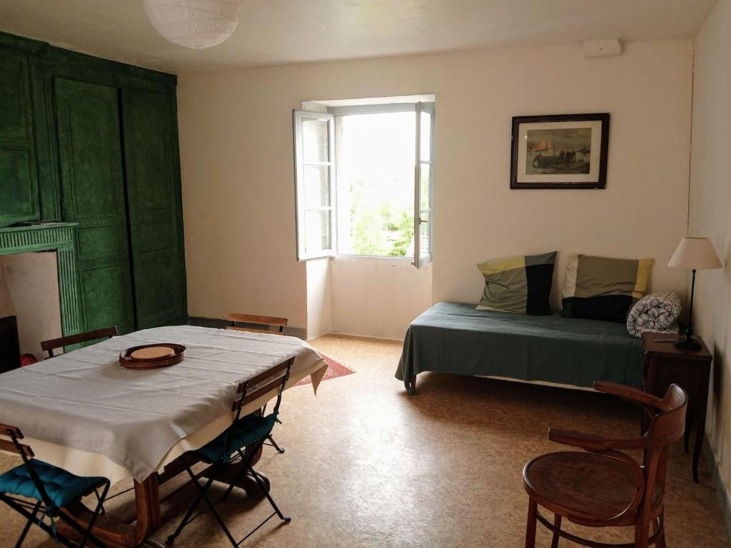 a living room with a bed and a table and chairs at 2-room apartment in Clamecy
