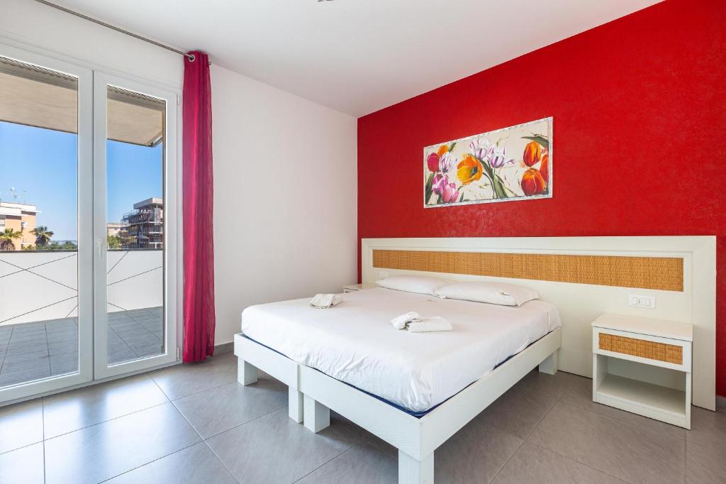 a bedroom with a white bed and a red wall at B&B Acquamarina in Gallipoli