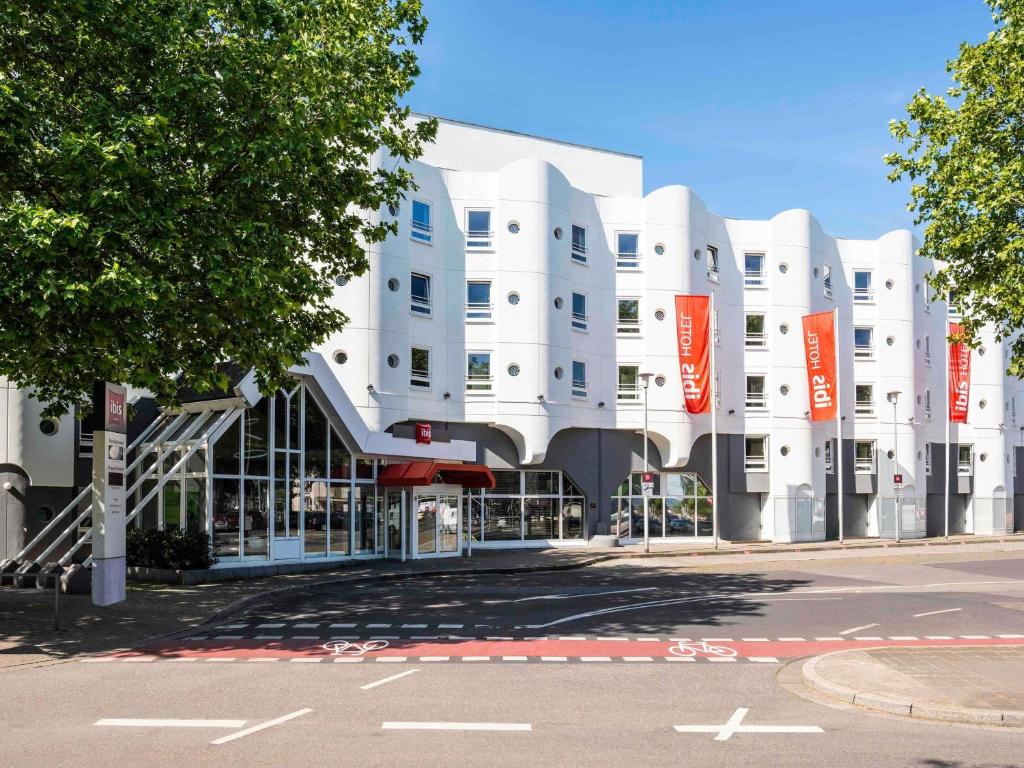 a white building with orange signs in front of it at ibis Heidelberg Hauptbahnhof in Heidelberg