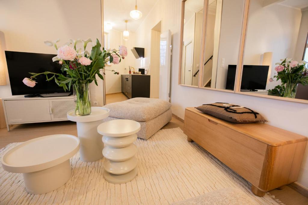 a living room with a vase of flowers in a room at Maison Lumière Arras in Arras