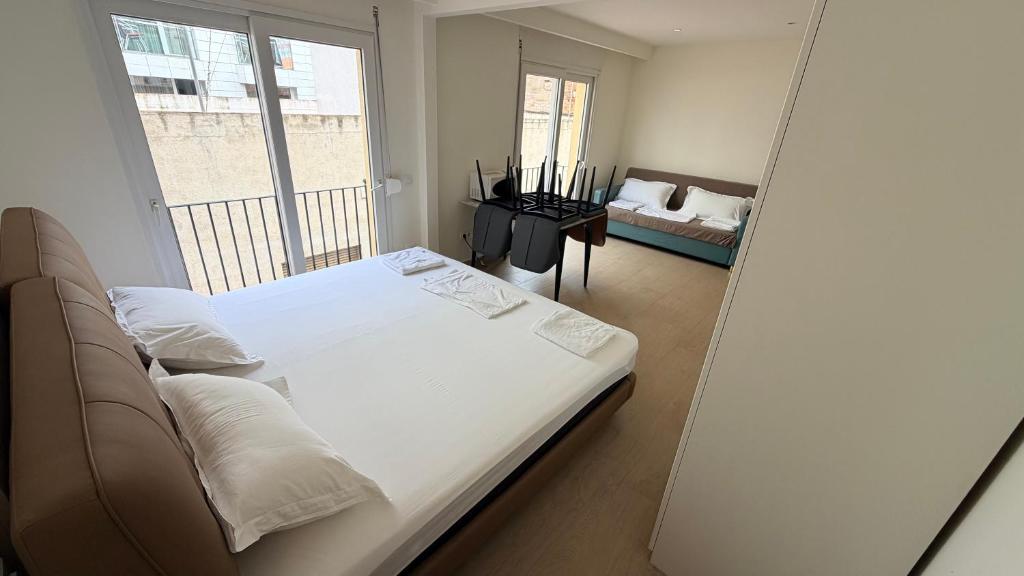 a bedroom with a bed and a balcony with a couch at Apartamentos Lin in Lloret de Mar