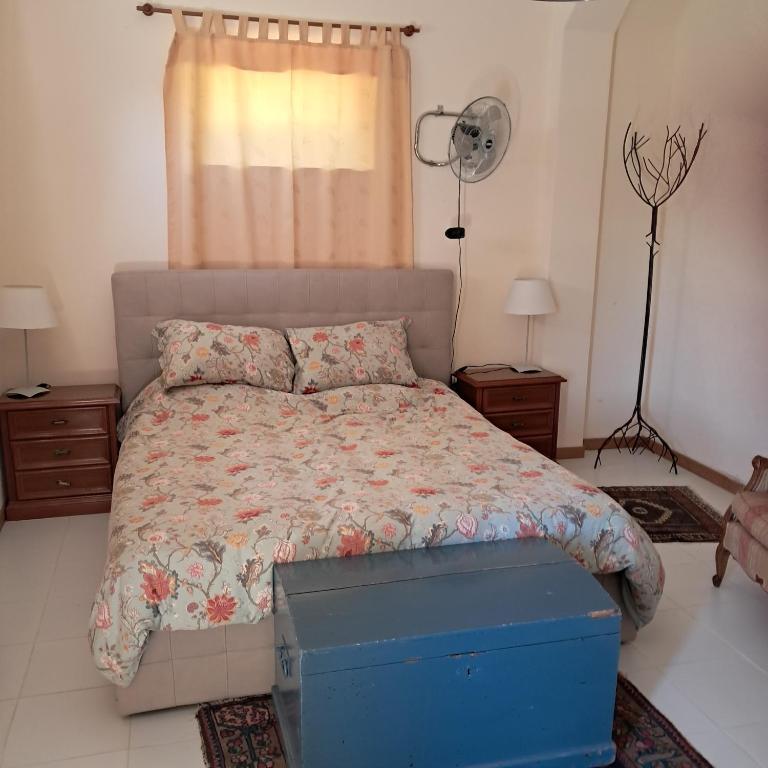 a bedroom with a bed with a blue box on it at Orchard House South Room in Pergola
