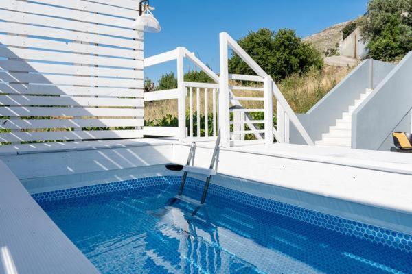 a swimming pool with a staircase and a swimming pool at Mary Luxury House in Émbonas