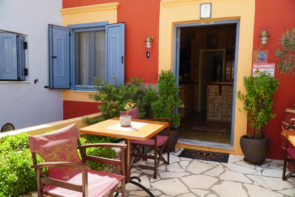 a patio with a table and chairs in front of a building at Taxiarchis in Symi