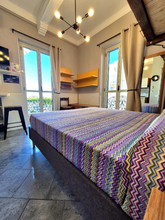 a bedroom with a bed with a colorful bedspread at Scilla Guest House in Scilla