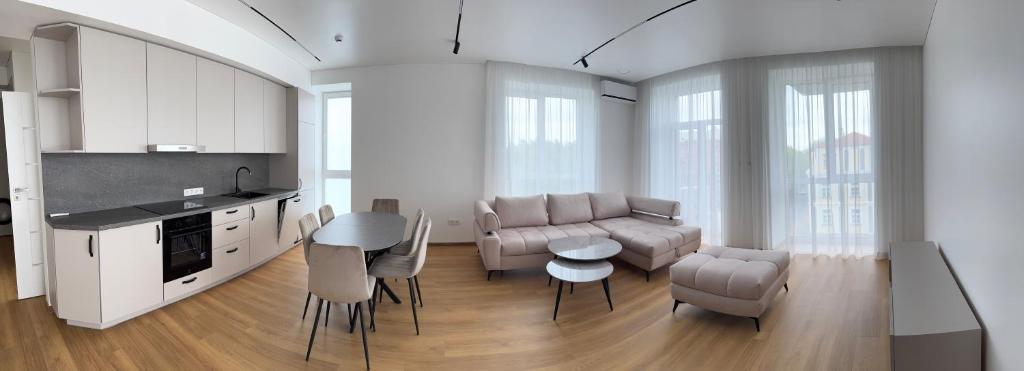 a kitchen and living room with a couch and a table at River View Apartment in the Park in Marijampolė