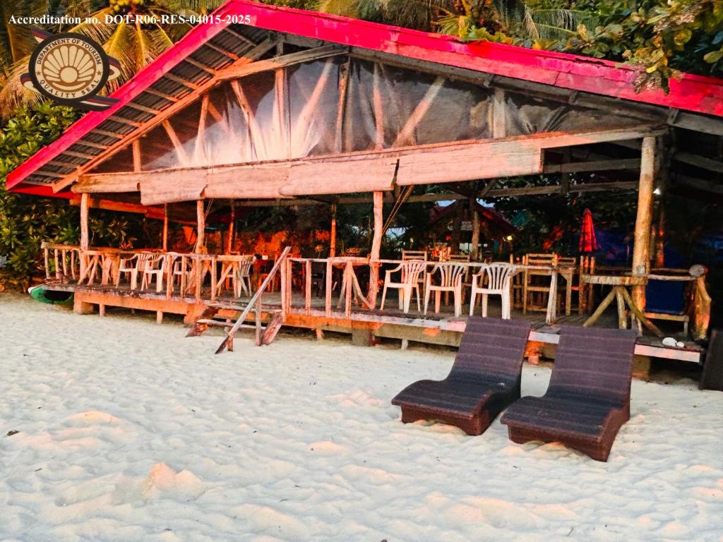 a restaurant with chairs and tables on the beach at White Beach Front and Cottages in Buruanga