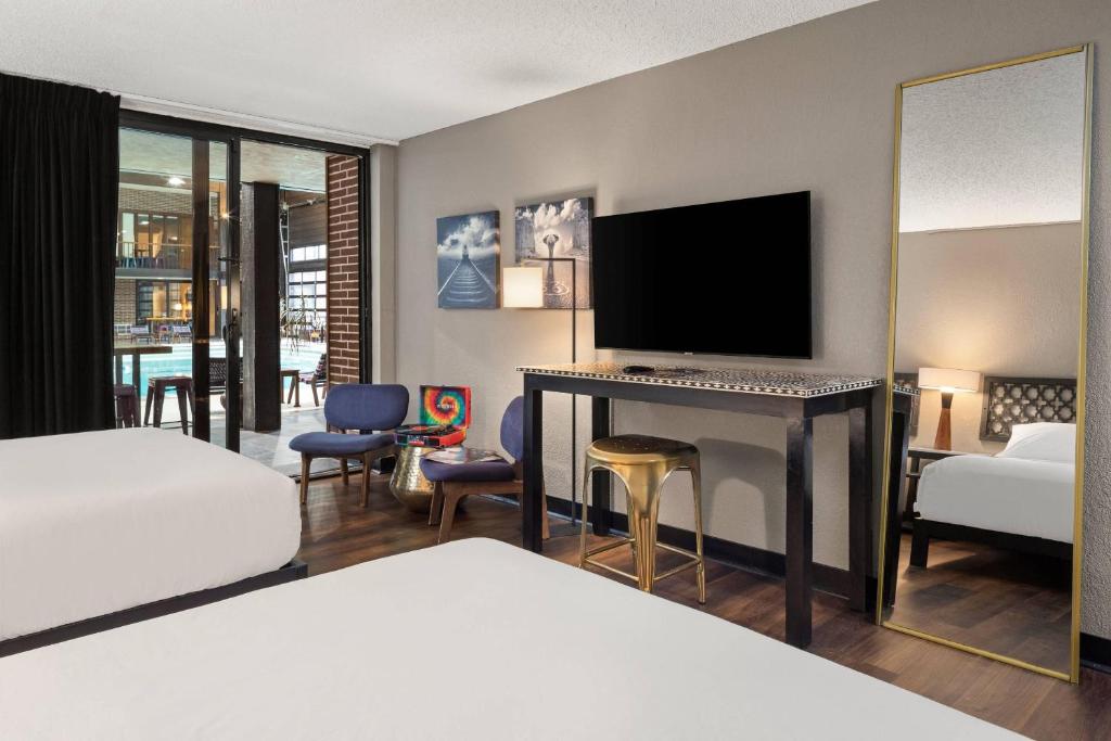a hotel room with a bed and a flat screen tv at The Highlander Hotel, Ascend Hotel Collection in Iowa City
