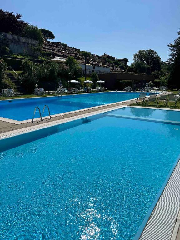 a large swimming pool with blue water at Casa Mariangela pool and garden in Leggiuno