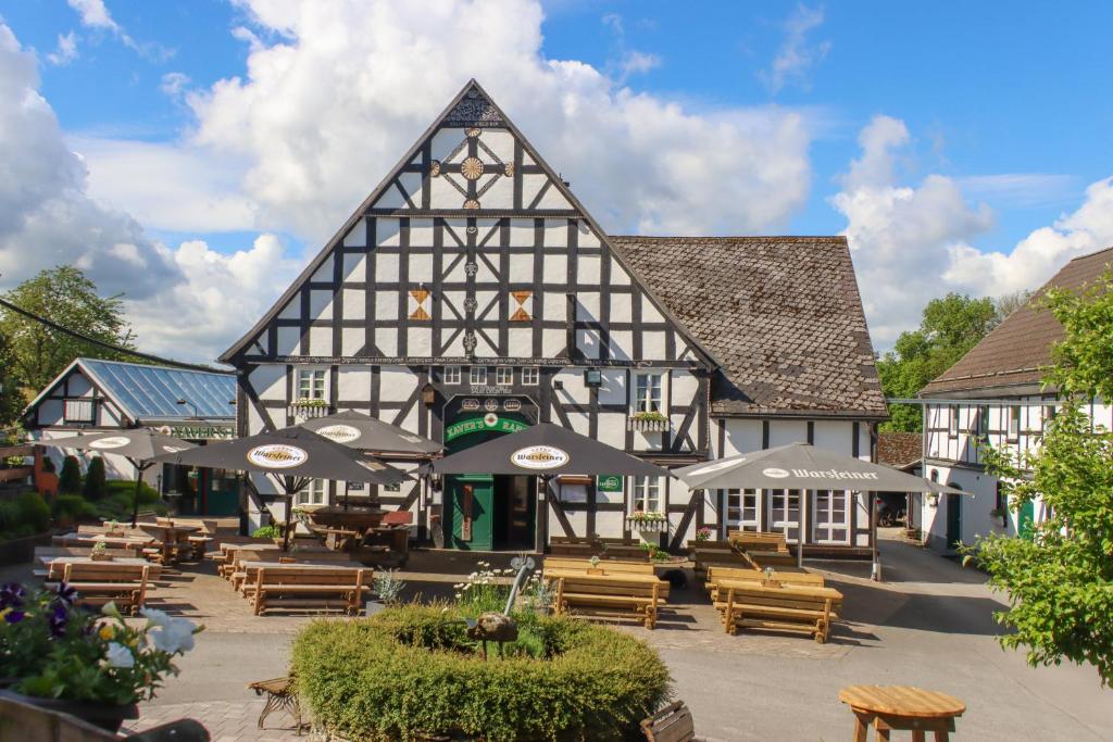 an old building with chairs and tables and umbrellas at Xavers Ranch in Meschede