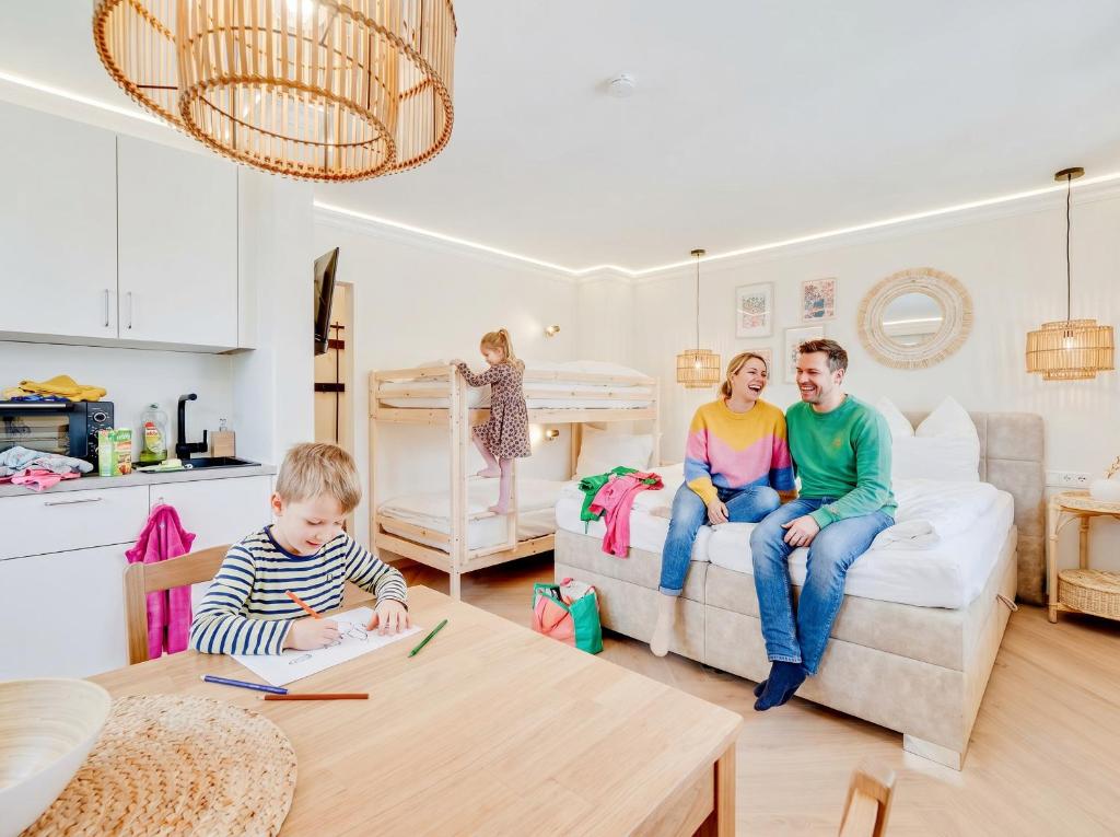 a family sitting on a couch in a living room at Zuhause am Kurgarten in Bad Reichenhall
