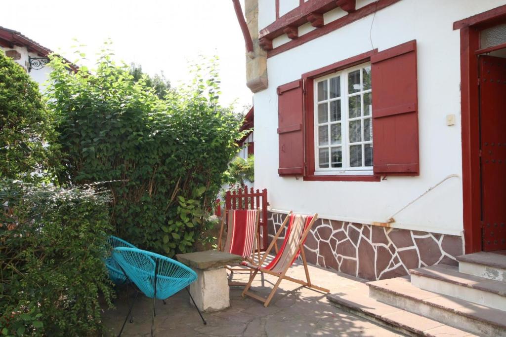 two chairs sitting outside of a house with a window at Etche alabena - 2 in Ainhoa