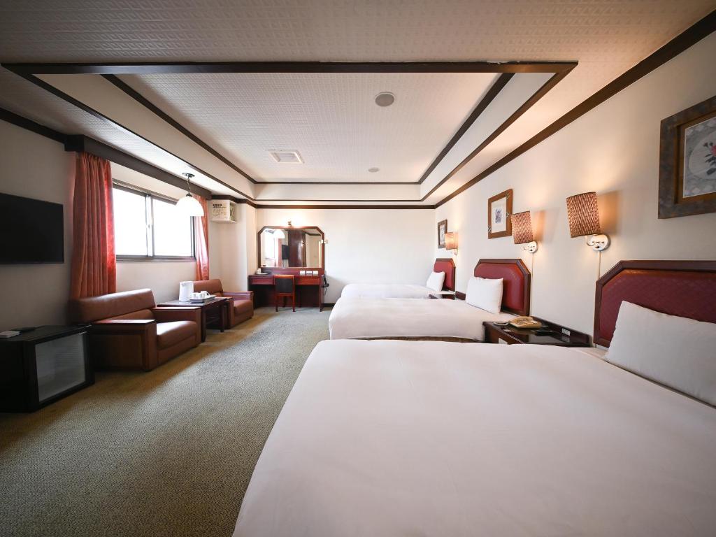a hotel room with two beds and a television at Guide Hotel Changhua Jhongjheng in Changhua City