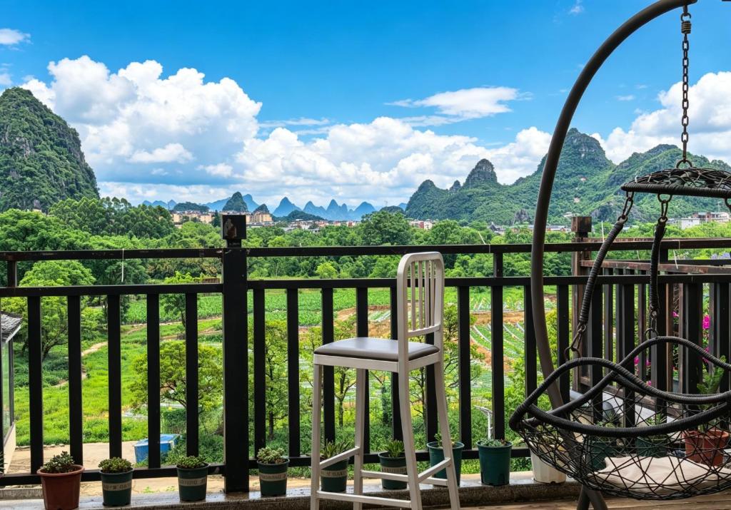 a chair on a balcony with mountains in the background at Guilin cozy mountain retreat in Guilin