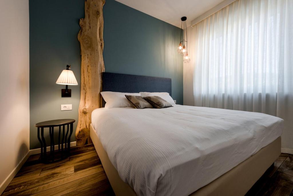 a bedroom with a large bed with a blue wall at Locanda la Cross - Adults Only in Garda