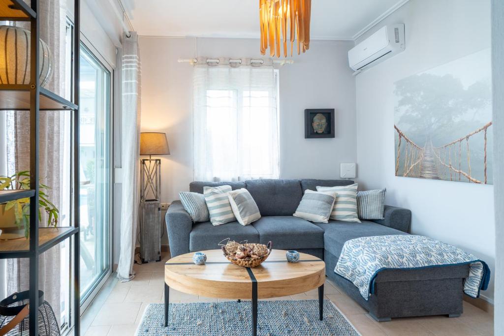 a living room with a couch and a table at Phoebes Place At Kalamaki Court, 2 Bedroom Villa With A Shared Pool - Fully Refurbished For 2026 in Kalamaki