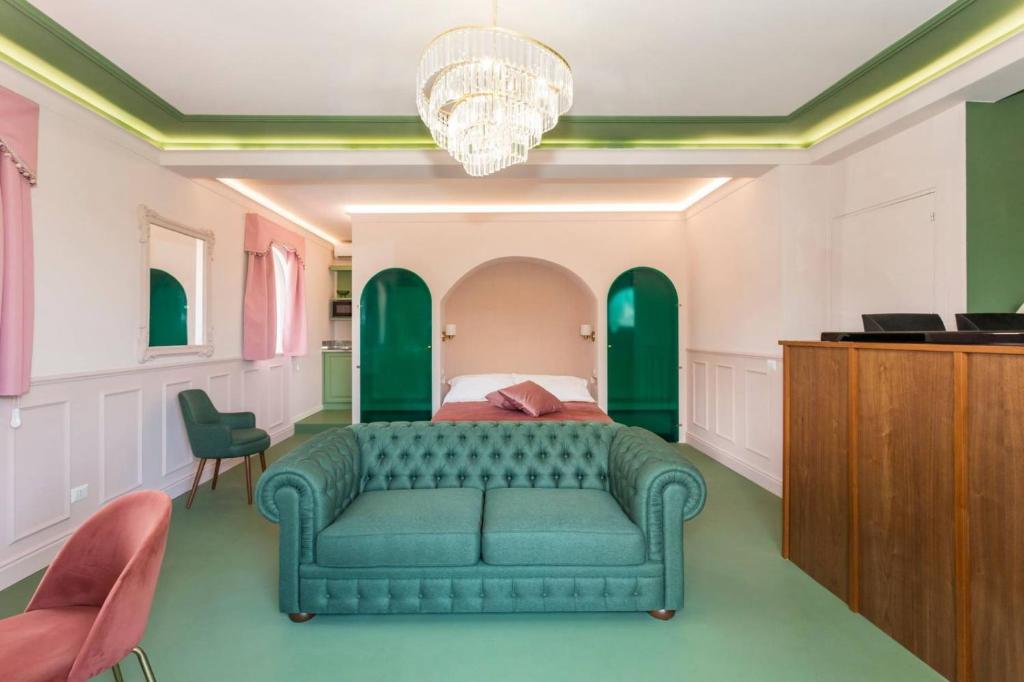 a bedroom with a green couch and a bed at Monforte's Etna Loft in Piedimonte Etneo