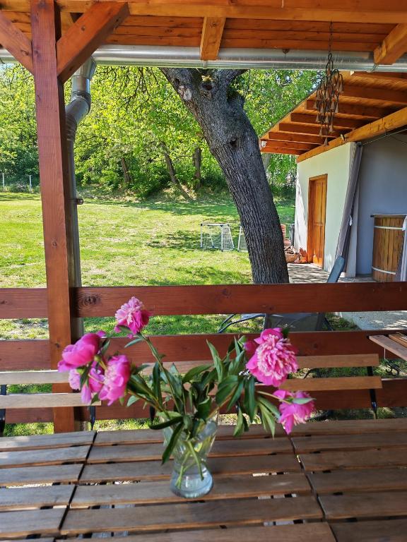 a vase of pink flowers sitting on a wooden table at Bakonyi Vénkörte Vendégház in Bakonypéterd