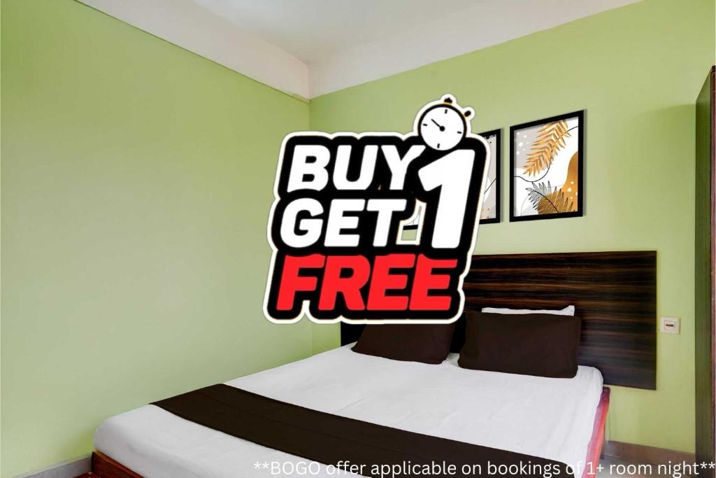 a bedroom with a bed with a buy get free sign on it at Super Hotel O Sankaradeva Kalakshetra Formerly HK Residency in Dispur