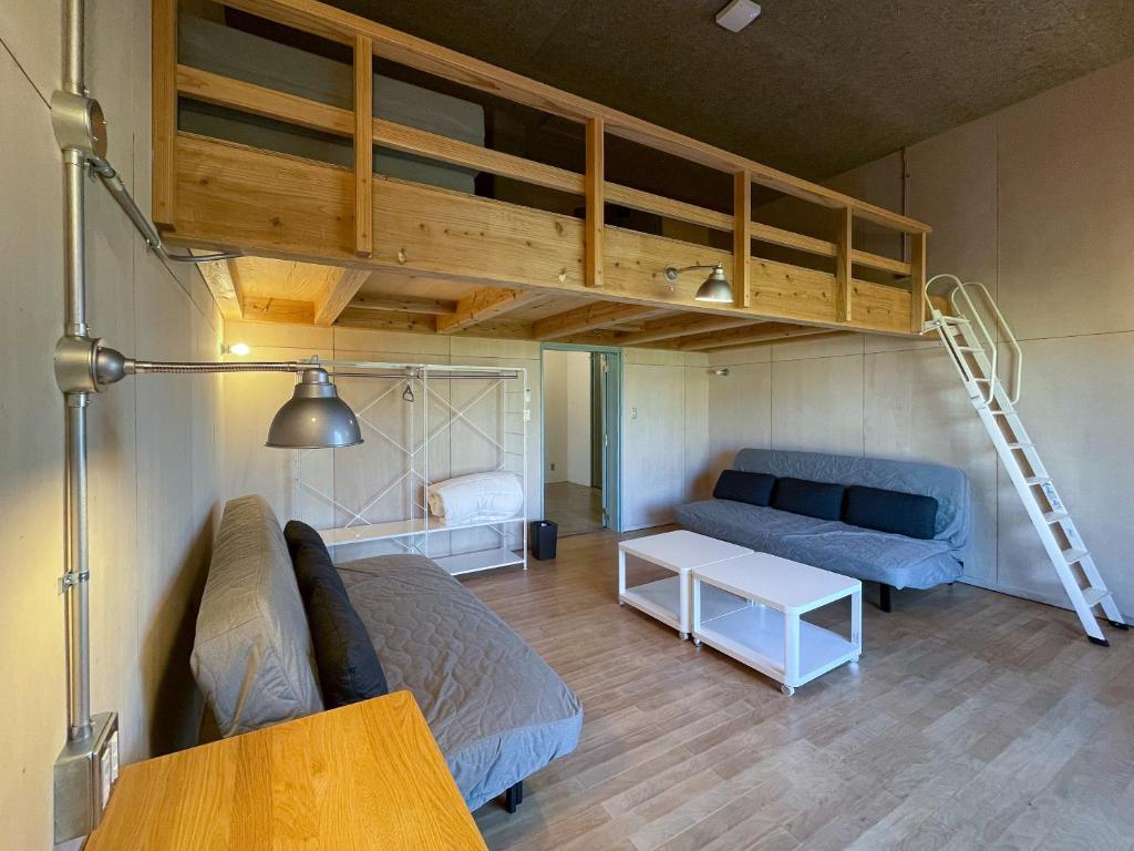 a living room with a bunk bed and a couch at cocomio in Bungoono