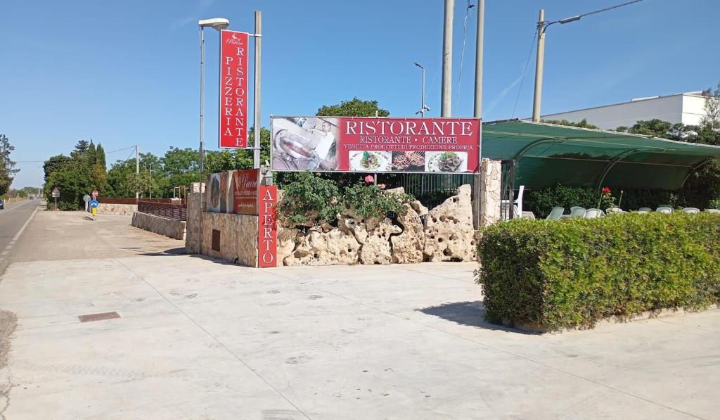 a sign for a restaurant on the side of a sidewalk at Agriturismo Il Pavone in Torre Lapillo