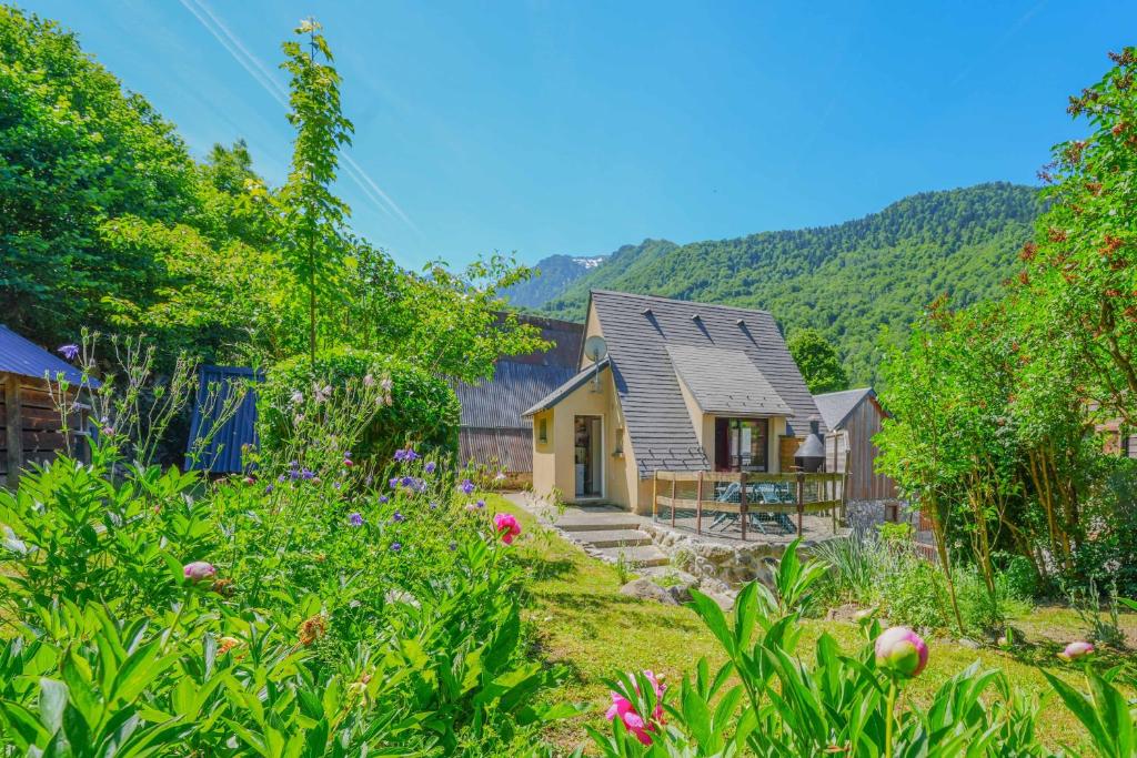 a small yellow house with mountains in the background at Chalet à Aulus-Les-Bains in Aulus-les-Bains