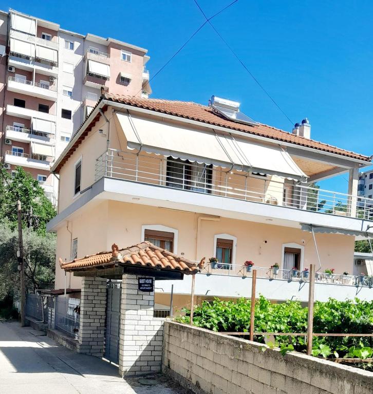 a house in front of a tall building at George's Ap Gjirokastër in Gjirokastër