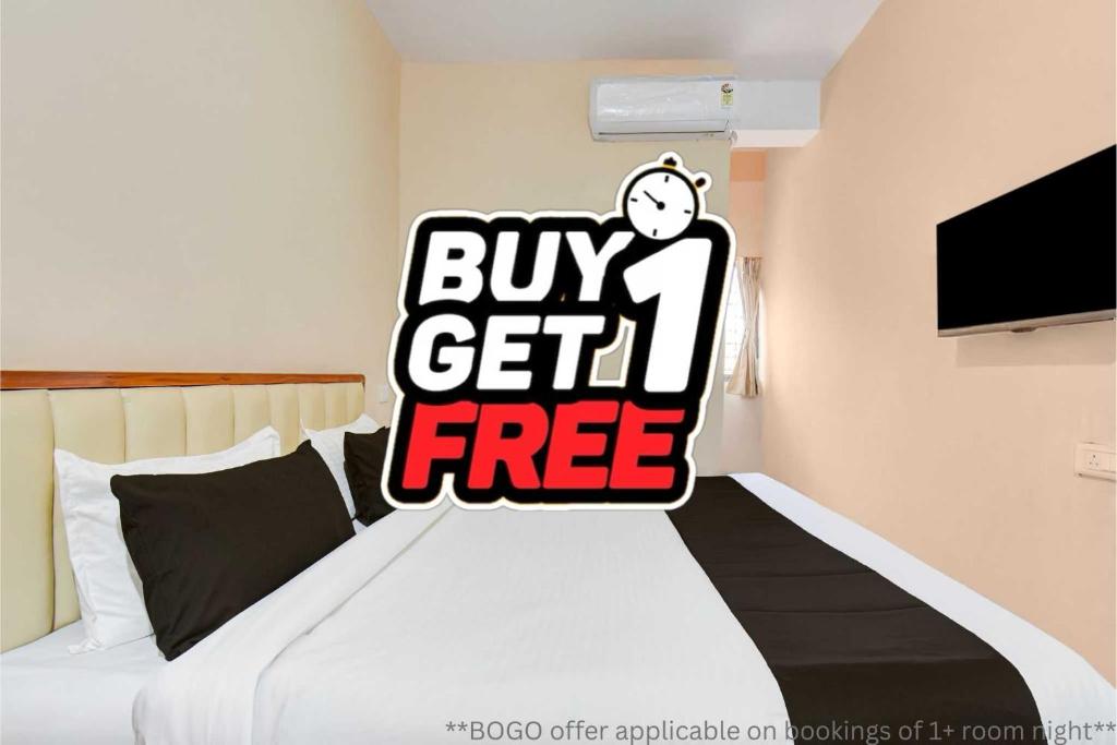 a bedroom with a bed with a buy get free sign at Super Hotel O Dehu Pune Formerly Gathaa Inn in Dehu