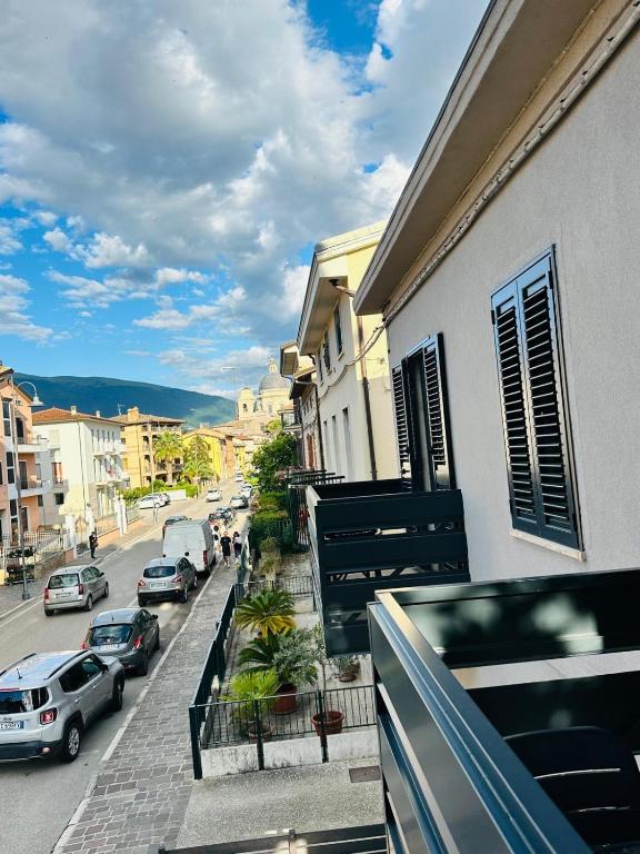 ein Balkon eines Gebäudes, auf dessen Straße Autos parken. in der Unterkunft SottoStelle in Santa Maria degli Angeli