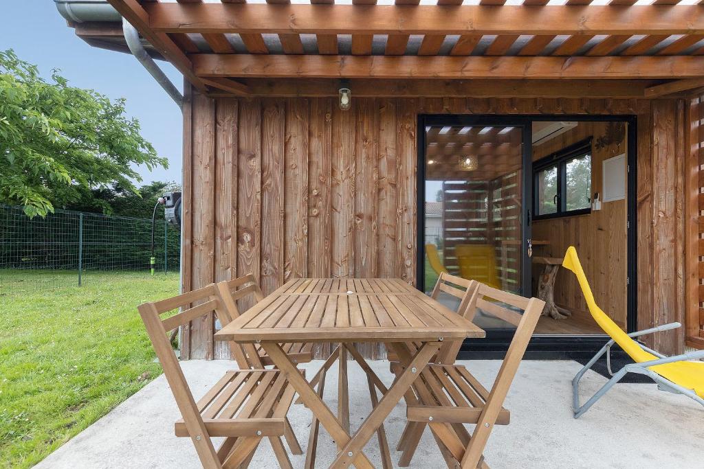a wooden table and chairs in front of a cabin at Ma cabane Océan in Le Verdon-sur-Mer