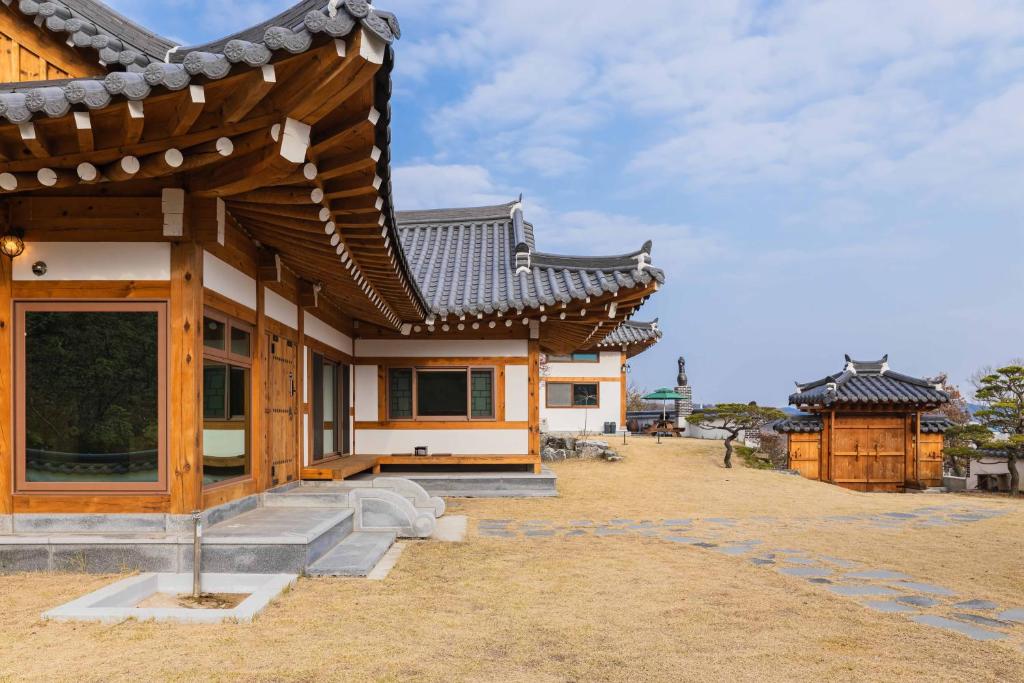 a building with a roof and steps in front of it at Luxury Hanok Blue Serenity in T'ongjin