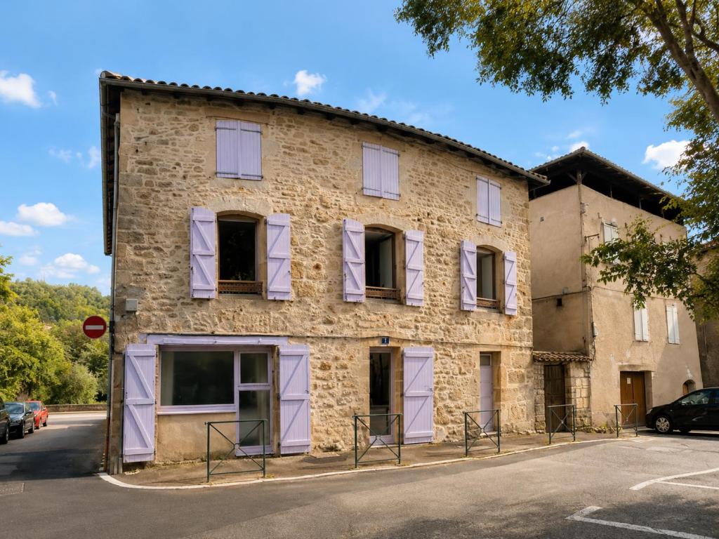 an old stone building with purple shuttered windows at Charmant T2 en RDC au centre de Figeac in Figeac