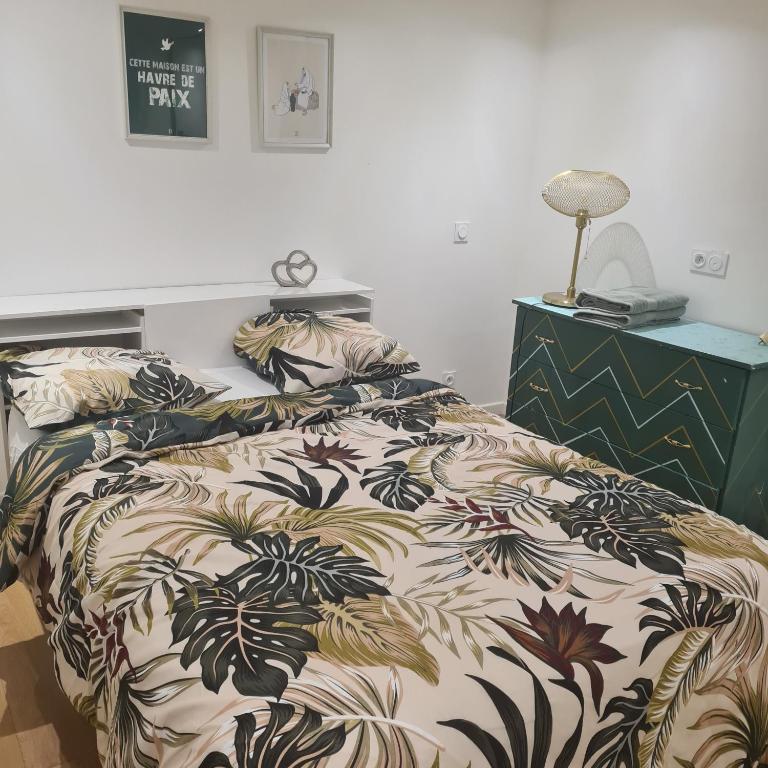 a bed with a comforter and pillows on it at Appart T2 indépendant in Dammarie-lès-Lys