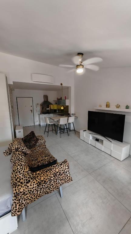 a living room with a leopard print couch and a television at Sole del Garda Haus in Desenzano del Garda