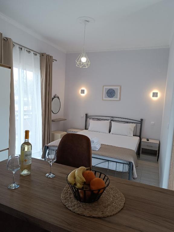 a room with a table with a bed and a bowl of fruit at Ioannis Fotinos Studios in Lygia