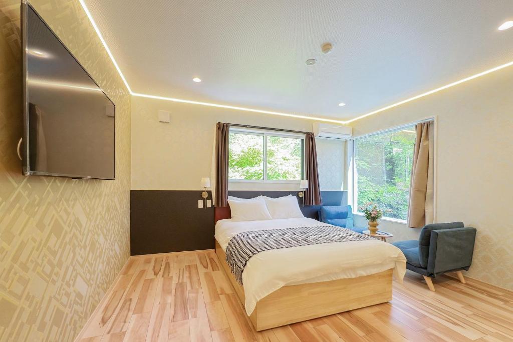 a bedroom with a bed and a chair and a window at 富士見莊sl0582 in Oshino