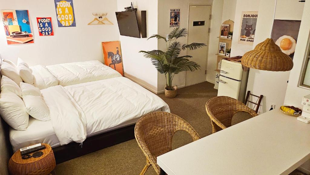 a room with a bed and a table and chairs at Hotel Amy in Pup'yŏng-yŏk