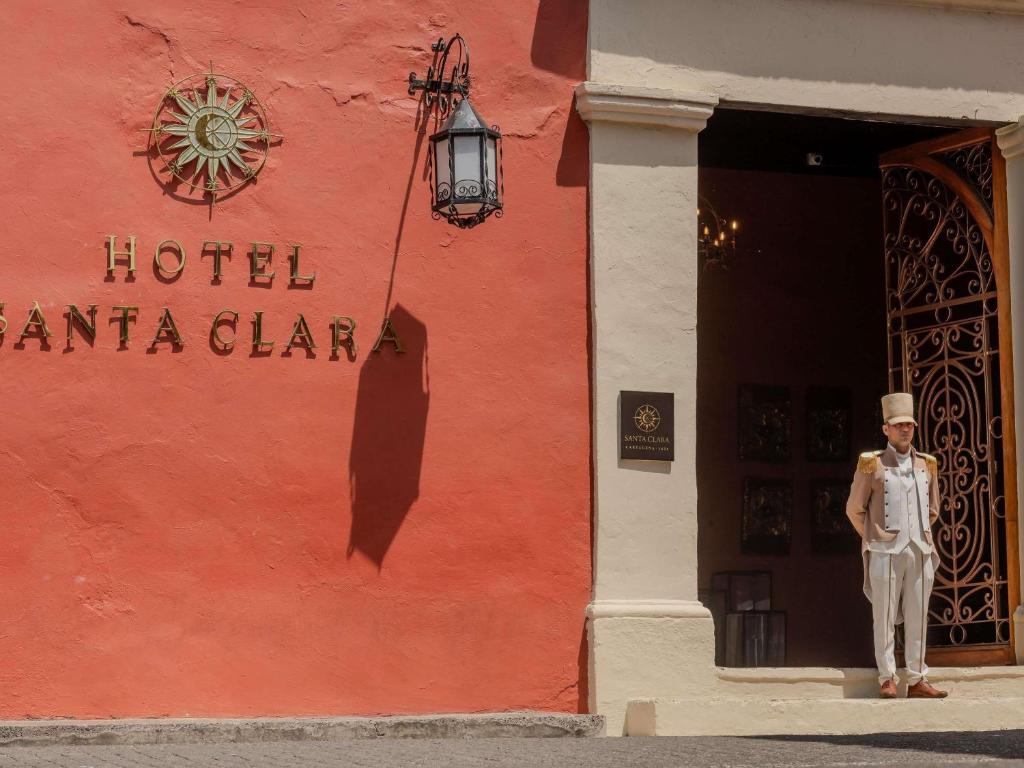 a man standing in front of a red building at Sofitel Legend Santa Clara Cartagena in Cartagena de Indias