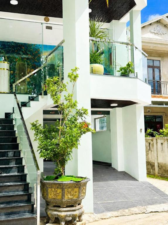 a building with a potted plant on the side of it at Victoria Hostel Huế in Hue