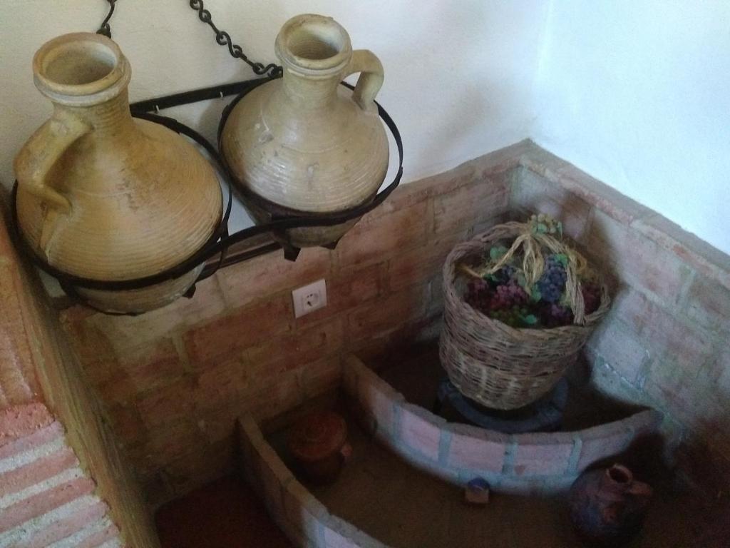 two vases are hanging on a wall with a basket at El Garrotal in El Bosque