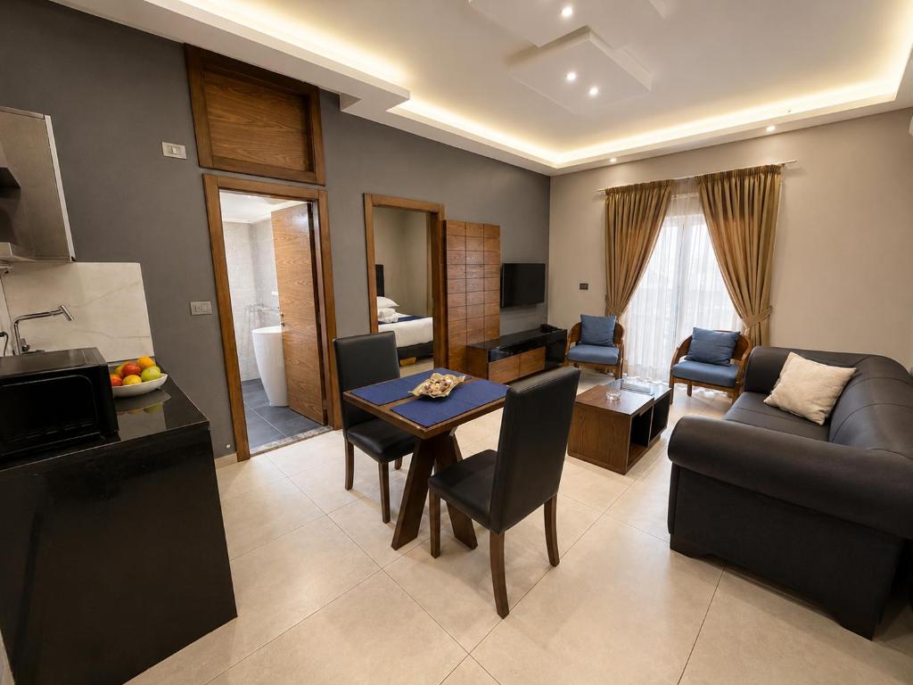 ein Wohnzimmer mit Sofa und Tisch in der Unterkunft Matar Residence Hotel Suites in Al Bawsharīyah